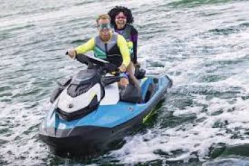 a man riding on the back of a boat in the water