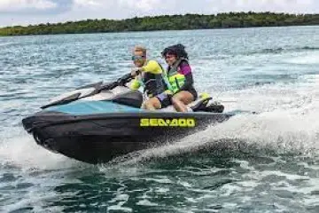 a man riding on the back of a boat in the water