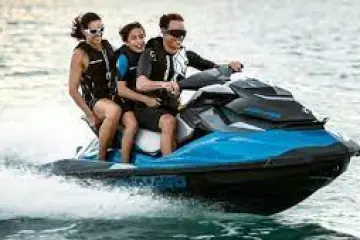 a man riding on the back of a boat in the water