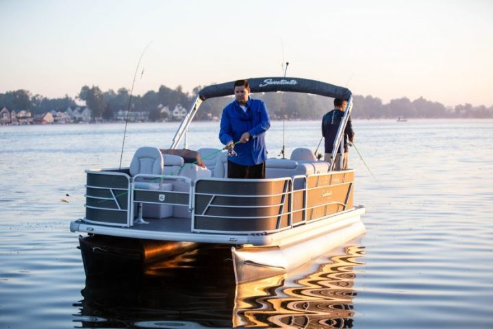 a man riding on the back of a boat in a body of water