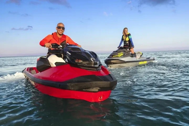 a man riding on the back of a boat in a body of water
